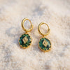 Gold plated Huggies hoop drop earrings featuring a vintage oval green natural stone charm with a gold diamond motif by eda jewels dubai