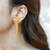 Nerida gold plated starfish earrings with cascading textured fringe chains worn by a model by Eda Jewels Dubai