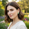 Noor gold plated hammered turquoise stud earrings worn by a model in a garden by Eda Jewels Dubai
