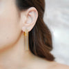 Ria gold plated hoop earrings with cascading two tone gold and silver beaded fringe worn by a model by Eda Jewels Dubai
