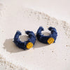 Tessa blue frayed denim gold plated wrapped hoop earrings featuring a gold plated flower charm accent by Eda Jewels Dubai