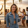 Tessa blue frayed gold plated denim hoop earrings with a gold plated floral accent worn by a model in a denim jacket at a beach party by Eda Jewels Dubai 