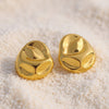Eda Jewels Dubai gold plated smooth organic molten teardrop statement earrings displayed on white sand