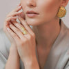 Eda Jewels Dubai gold plated textured Aluna wrap ring and Seashell Nautila statement stud earrings with turquoise trim thread worn by a model