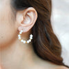 Eda Jewels Dubai gold plated freshwater pearl open hoop earrings with small gold spacer beads worn by a model.