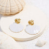 Gold-plated Aruba earrings by Eda Jewels, featuring a delicate shell and starfish design with white shell accents. Perfect for everyday wear or gifting