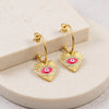 Eda Jewels Dubai gold plated crescent hoop drop earrings featuring textured heart charms with a pink enamel evil eye design