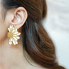June gold plated white flower earrings by Eda Jewels Dubai. Perfect statement piece for daily wear and gifting.