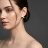 Vira gold plated drop earrings featuring delicate mother of pearl white flower petals with gold centers worn by a model by Eda Jewels Dubai